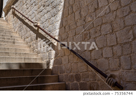 Stone hand holding stairway railing in the Rectors Palace in Dubrovnik, Croatia. Stone hand holding stairway railing in the Rectors Palace in Dubrovnik, Croatia. 75356744