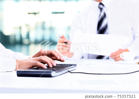 2 businessmen with laptop and blank paper sitting at the desk 75357321