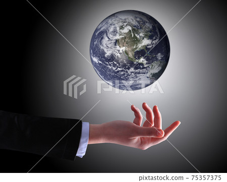 Business woman holding a ball of people on a dark background Business woman holding a ball of people on a dark background 75357375