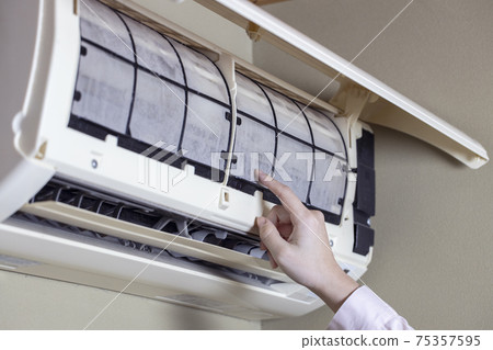 Dirty air conditioner filter and female hand inspecting 75357595