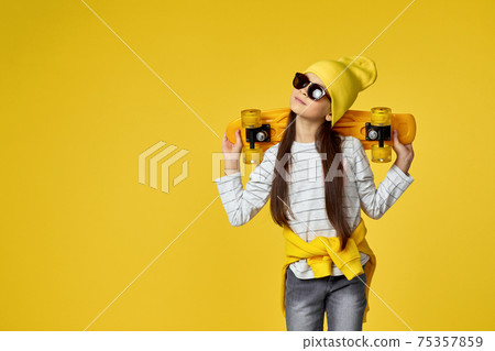 child girl in hat and sunglasses with yellow skateboard child girl in hat and sunglasses with yellow skateboard 75357859