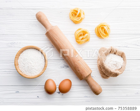 Ingredients for homemade pasta  flour and eggs on wooden background. 75358889