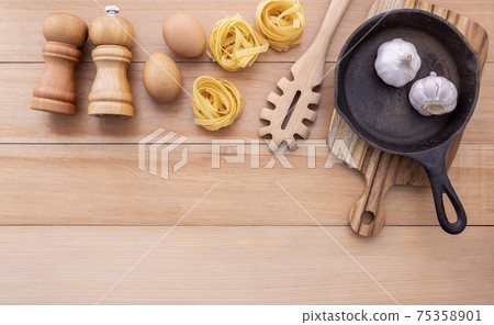 Italian foods concept and menu design . Empty cast iron skillet and  pasta ladle on wooden background. 75358901