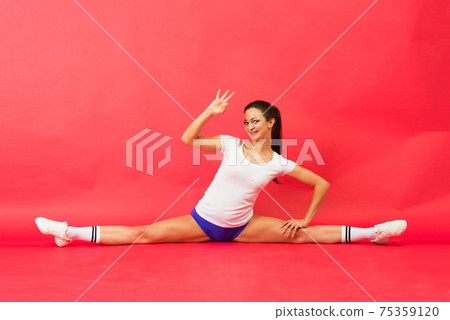Beautiful young fit gymnast woman in sportswear working out, performing art gymnastics element Beautiful young fit gymnast woman in sportswear working out, performing art gymnastics element 75359120