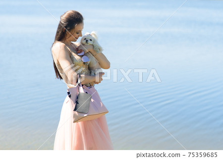Puppy white dog with it's owner. Concept about friendship, animal and freedom. Puppy white dog with it's owner. Concept about friendship, animal and freedom. 75359685