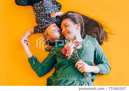 Daughter gives gift to her mother. Congratulations to the parents on the holiday 75360207