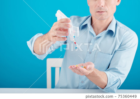 Man taking pills and supplements Man taking pills and supplements 75360449