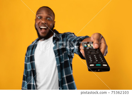 Excited African Man Pointing Television Controller To Camera, Yellow Background 75362103