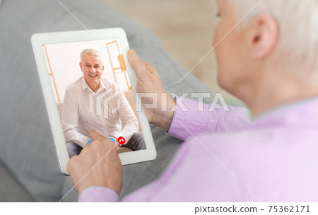 Distance communication. Senior woman chatting with her husband online, having video call on tablet from home 75362171