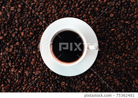 White plate, cup of coffee on a bunch of roasted coffee beans background White plate, cup of coffee on a bunch of roasted coffee beans background 75362481