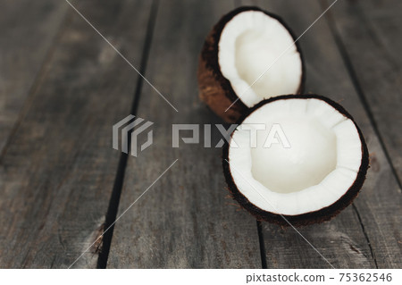 Broken coconuts on gray wooden background. White coconut pulp 75362546