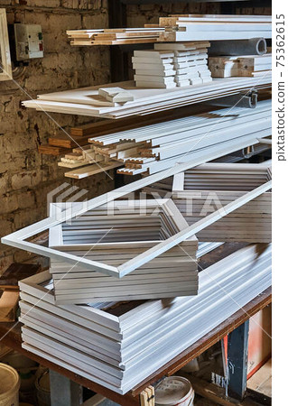 Stacked door moldings and architraves made of MDF in workshop 75362615