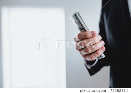 One hundred dollar bills money bundle, in hand of man in suit and white shirt 75362814