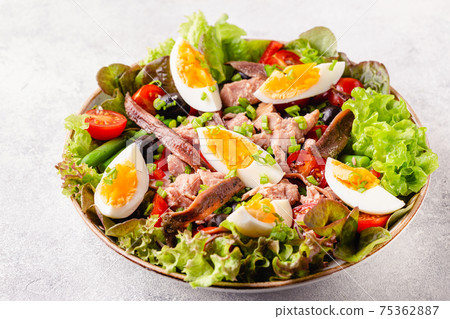 salad Nicoise with tuna, eggs, green beans, tomatoes,  olives, lettuce and anchovies 75362887