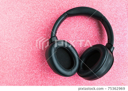 Big black headphones on pink glitter background.  75362969
