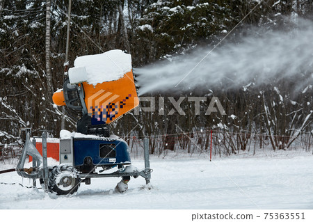 Snow cannon spraying out a fresh dusting of snow on the ski slopes. Snow cannon spraying out a fresh dusting of snow on the ski slopes. 75363551