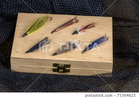 Wooden Fly Box with Salmon Flies on a Fishing Net and Outdoor Coat 75364625
