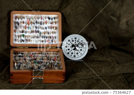 Wooden Fly Box and Fly Reel on an Outdoor Coat 75364627