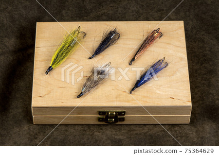 Wooden Fishing Fly Box with Salmon Flies on an Outdoor Coat 75364629