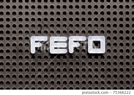 White color letter in word FEFO (first expired first out) on black pegboard background 75366222