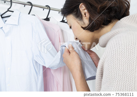 Woman hanging laundry in the bathroom Woman hanging laundry in the bathroom 75368111