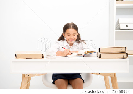 Excellent pupil. Girl child writes hometask while sit table  75368994