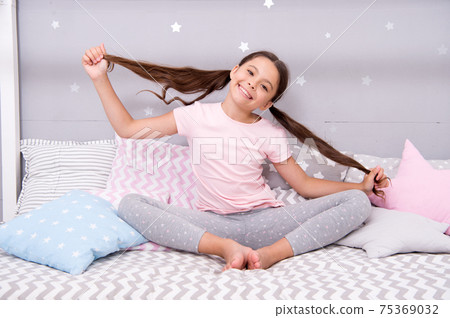Girl child sit on bed in her bedroom. Kid prepare hair 75369032
