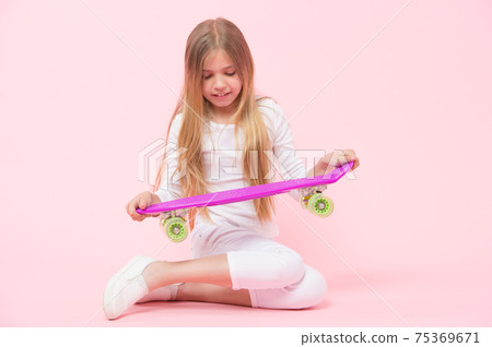 A skater girl or skateboarder. Little girl holding skateboard 75369671