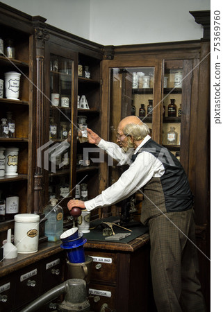 Museum Past of Physic Preparation. Kiev, Ukraine, 2017. Glass phial, oil ointment, vial, herb elixir, flask, jar, pot, pill set. Aged druggist case. Rustic interior of obsolete wood storage cabinet 75369760