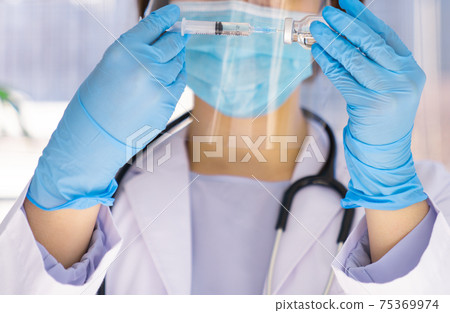 Doctor pulling vaccine from vial Doctor pulling vaccine from vial 75369974
