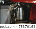 Old coffee machine, with one iron mug, espresso is poured into it 75370163