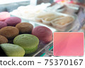 Showcase with desserts, macarons different colors are in the foreground 75370167