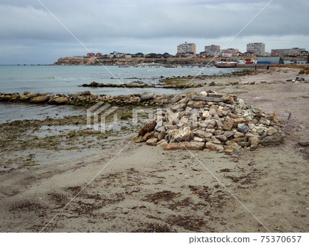 Pile of stones by the sea. 75370657
