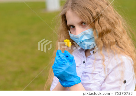 Portrait of sad caucasian child in face mask on closed playground outdoor. Portrait of sad caucasian child in face mask on closed playground outdoor. 75370783