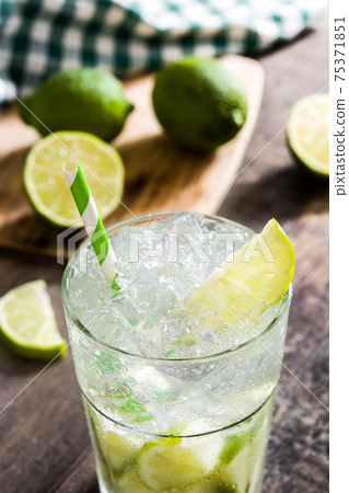 Caipirinha cocktail in glass on wooden table background Caipirinha cocktail in glass on wooden table background 75371851
