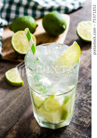 Caipirinha cocktail in glass on wooden table background Caipirinha cocktail in glass on wooden table background 75371852