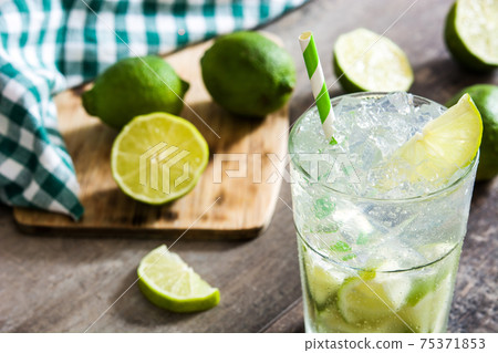 Caipirinha cocktail in glass on wooden table background Caipirinha cocktail in glass on wooden table background 75371853