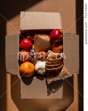 Healthy food delivery flat lay harsh shadows. Take away natural organic products.Donation box New normal online shopping Healthy food delivery flat lay harsh shadows. Take away natural organic products.Donation box New normal online shopping 75372664