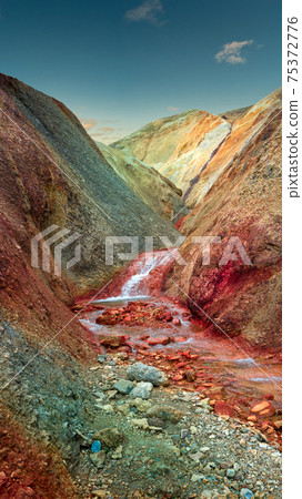 Iconic colorful rainbow volcanic mount Brennisteinsalda (Sulphur Wave) in Landmannalaugar mountain region in Iceland at sunset and blue sky. 75372776