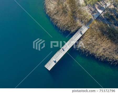 Aerial view of wood pier with fishers and their fishing rods at the Miramar lake, San Diego 75372796