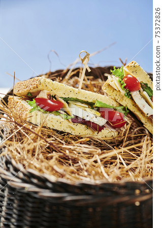 A basket of pita bread pockets filled with ham and salad. Healthy eating. A basket of pita bread pockets filled with ham and salad. Healthy eating. 75372826