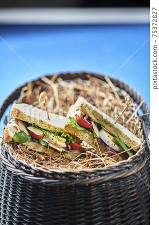 A basket of pita bread pockets filled with ham and salad. Healthy eating. A basket of pita bread pockets filled with ham and salad. Healthy eating. 75372827
