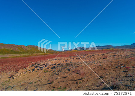 Colorful geothermal active zone Hverir near Myvatn lake in Iceland, resembling Martian red planet landscape, at summer and blue sky. Colorful geothermal active zone Hverir near Myvatn lake in Iceland, resembling Martian red planet landscape, at summer and blue sky. 75372871