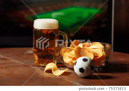Glass with beer and chips. Soccer fans idea Glass with beer and chips. Soccer fans idea 75373813