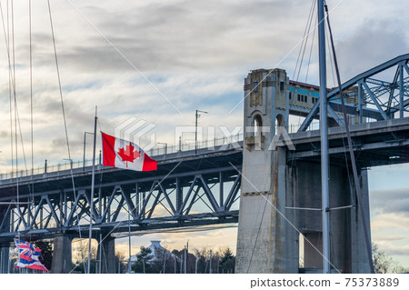 National Flag of Canada with Burrard Street Bridge in the background. Vancouver, British Columbia, Canada. 75373889