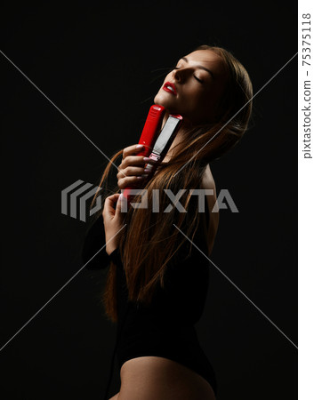Young pretty woman model hold hair straightener in 75375118