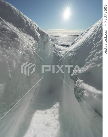 Ice slopes in sunny winter day, transparent ice of blue color, purely blue sky, long shadows, a pure snow-covered virgin soil, snow barkhans, Ice slopes in sunny winter day, transparent ice of blue color, purely blue sky, long shadows, a pure snow-covered virgin soil, snow barkhans, 75375609