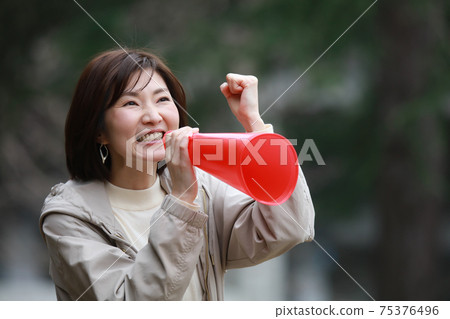 一個女人拿著擴音器和歡呼 一個女人拿著擴音器和歡呼 75376496