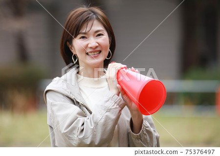 一個女人拿著擴音器和歡呼 75376497