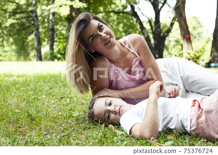 young pretty mother walking with little cute daughter outside in green park, lifestyle poeple concept young pretty mother walking with little cute daughter outside in green park, lifestyle poeple concept 75376724